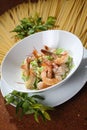 Vertical shot of spinach pasta with fresh shrimp and guajillo chili on a white salad plate Royalty Free Stock Photo