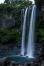 Vertical shot of the splashing flowing Jeongbang waterfall in Jeju Island, South Korea Royalty Free Stock Photo