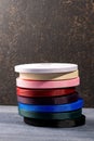 Vertical shot of a stack of colored fabric rolls for fashion design