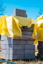 Vertical shot of a stack of gray bricks near a construction site