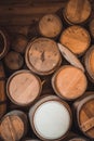 Vertical shot of stack of old wine barrels in the wooden basement Royalty Free Stock Photo