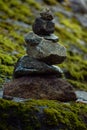 Vertical shot of stacked rocks on a lush green mossy surface