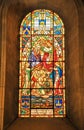Vertical shot of a stained glass window of the Coronation of the Virgin church