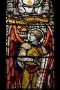Vertical shot of a stained glass window featuring scripture and knights, Scotland, UK