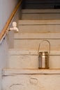 Vertical shot of stairs, a brass milk bucket and a water tap attached to a rusty pipe in the wall