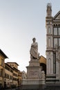 Vertical shot of The Statue of Dante Alighieri with the Basilica of Santa Croce in the background