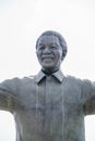 Vertical shot of a statue of a happy man standing with his hands opened