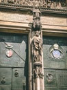 Vertical shot of a statue, old emblems, and inscription in Cologne Cathedral in Germany.