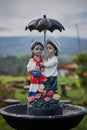Vertical shot of a statue of a young couple holding an umbrella outdoors Royalty Free Stock Photo
