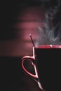 Vertical shot of steam coming out of a red mug with hot drink Royalty Free Stock Photo