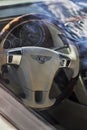 Vertical shot of the steering wheel of Bentley Continental GT Car with beige interior