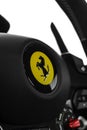 Vertical shot of the steering wheel of a Ferrari 812 Superfast with the logo on it