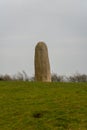 Vertical shot of the Stone of Destiny at the Hill of Tara In Ireland on a cloudy day