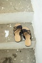 Vertical shot of stone stairs going up with sandals on the stairs a baby's footprint painted