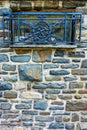 Vertical shot of stone wall texture with blue wrought iron grates