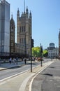 Vertical shot of the streets of London, UK with people and the Victoria tower in the background.