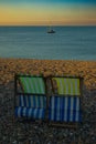 Vertical shot of striped deckchairs on the beach