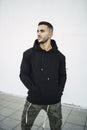 Vertical shot of a stylish attractive young man wearing a black hoodie Royalty Free Stock Photo