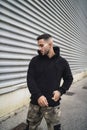 Vertical shot of a stylish attractive young man wearing a black hoodie Royalty Free Stock Photo