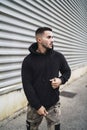 Vertical shot of a stylish attractive young man wearing a black hoodie Royalty Free Stock Photo