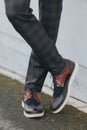 Vertical shot of a stylish man in gray check suit pants and tricolor leather brogue shoes