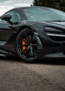 Vertical shot of the stylish rims of a luxurious black McLaren automobile