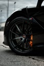 Vertical shot of the stylish rims of a luxurious black McLaren automobile
