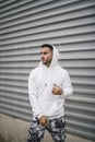 Vertical shot of a stylish young man wearing a white hoodie Royalty Free Stock Photo