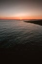 Vertical shot of the sunset over the beautiful calm ocean captured in Westkapelle, Netherlands Royalty Free Stock Photo