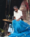 Vertical shot of a tailor working on the roadside in Kolkata, India