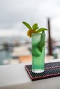 Vertical shot of a tall glass with a bright green cocktail with mint Royalty Free Stock Photo