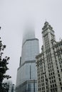 Vertical shot of a tall skyscraper and The Wrigley Building covered in mist in Chicago, Illinois