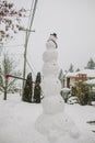 Vertical shot of a tall snowman in a backyard