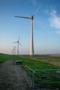 Vertical shot of tall wind-turbines along the Westermeerdijk in the Netherlands