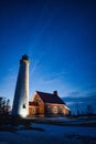 Vertical shot of Tawas Point Lighthouse near building in winter Royalty Free Stock Photo