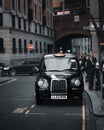 Vertical shot of a taxi waiting on a crowded street in London, UK