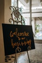 Vertical shot of the text " Welcome to our beginning" on the small vintage blackboard