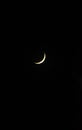 Vertical shot of a thin crescent moon in a dark night sky Royalty Free Stock Photo