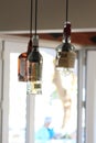 Vertical shot of three bottles hung from lamp wires Royalty Free Stock Photo