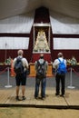 Vertical shot of three men in front of the icon of the virgin of Rocio during the pilgrimage