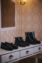 Vertical shot of three pairs of black shoes on the table in the room