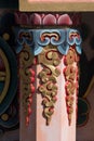 Nepal,Vertical shot of Tibetan buddhist ornamented orange pillars and Chackra wheel in the background.