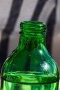 Vertical shot of the tip of a green bottle against a blurred background Royalty Free Stock Photo