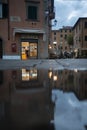 Vertical shot of a tobacco store reflecting in water puddle in Portoferraio Elba