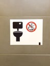 Vertical shot of the toilet sign with garbage prohibited symbol on the wall