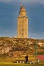 Vertical shot of a tourist admiring the Tower of Hercules in Coruna, Galicia, Spain