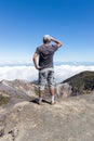 Vertical shot of tourist contemplating the view of the crater of a volcano in the Irazu Volcano National Park in Costa Rica on a