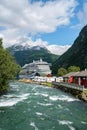 Vertical shot of the tourist ferry on Fjord Sea near the port in Geiranger village, Norway Royalty Free Stock Photo
