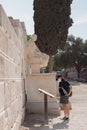 Vertical shot of the tourist reading about the Theatre of Dionysus near the statue of Menander