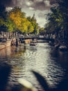 Vertical shot of a touristic canal in Amsterdam and the Basilica of Saint Nicholas in the background Royalty Free Stock Photo